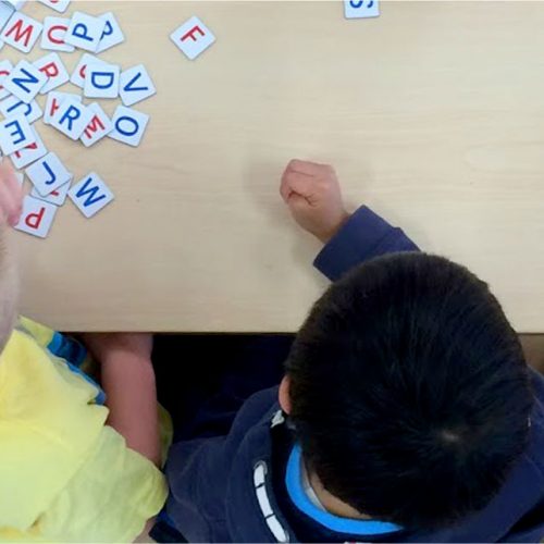 Looking over childrens heads at letters on a table